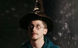 Man in a hoodie wearing a wizard hat, symbolizing the fusion of tech-savvy communication and human-centered service. callwizards-courtney-jordan-neyius